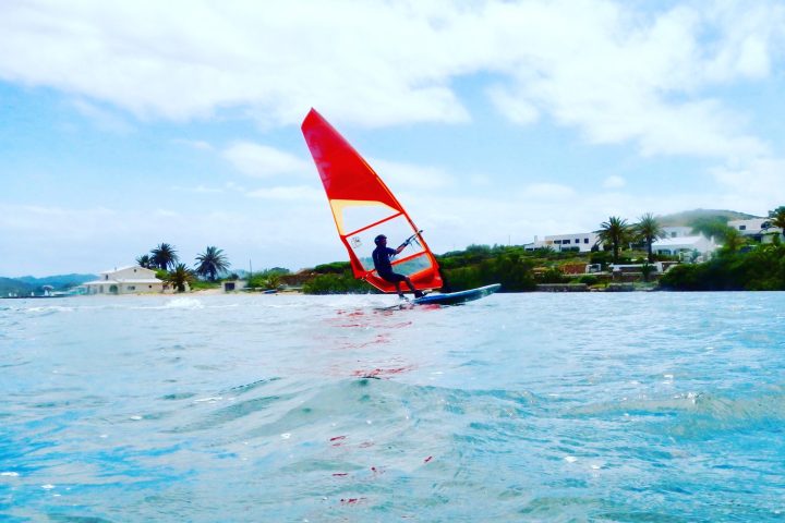 a person flying a kite in a large body of water