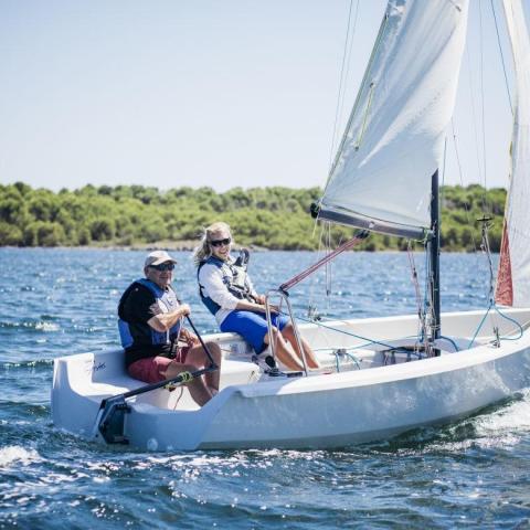 a man riding on the back of a boat in the water
