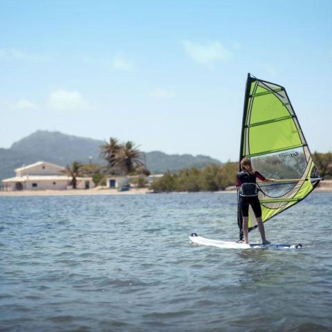 a man riding on the back of a boat in a body of water