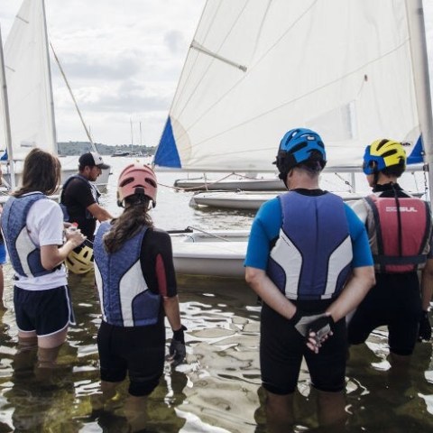 a group of people standing on a boat in the water