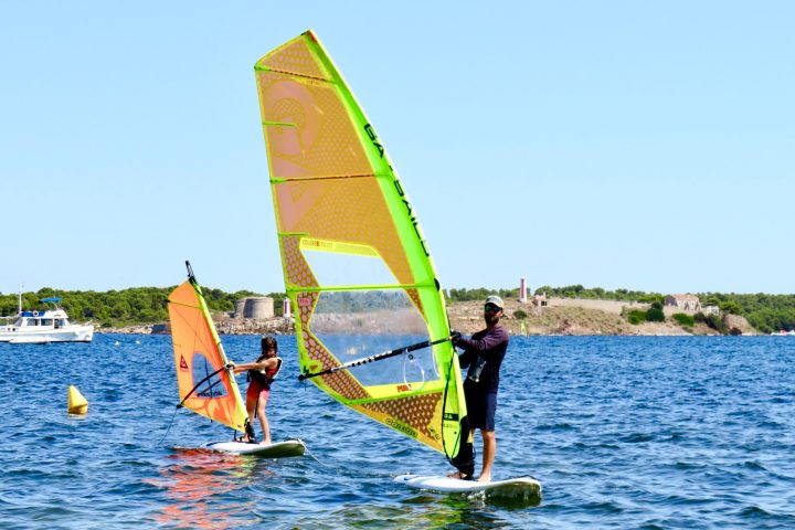 a man holding a kite in a boat on the water