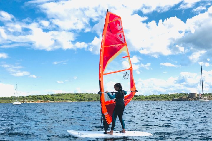a man holding a kite in a large body of water