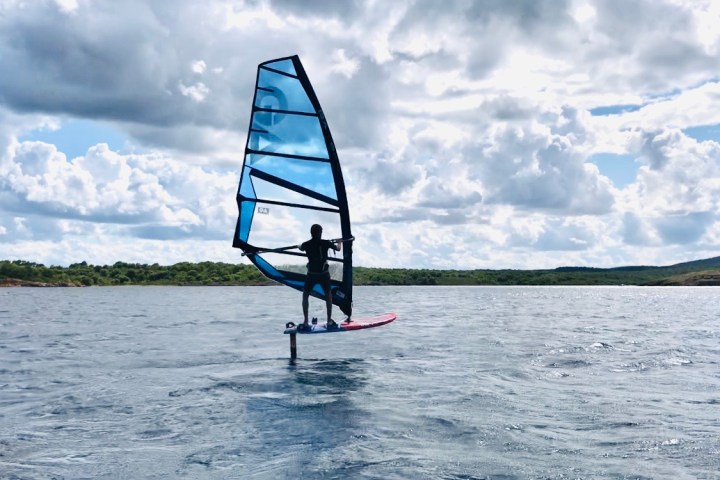 a man riding on the back of a boat in a body of water