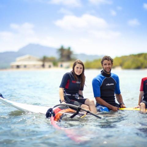 a group of people windsurfing a boat in the water