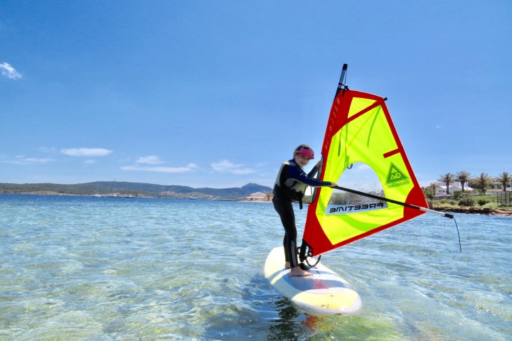 a man flying a kite in a large body of water