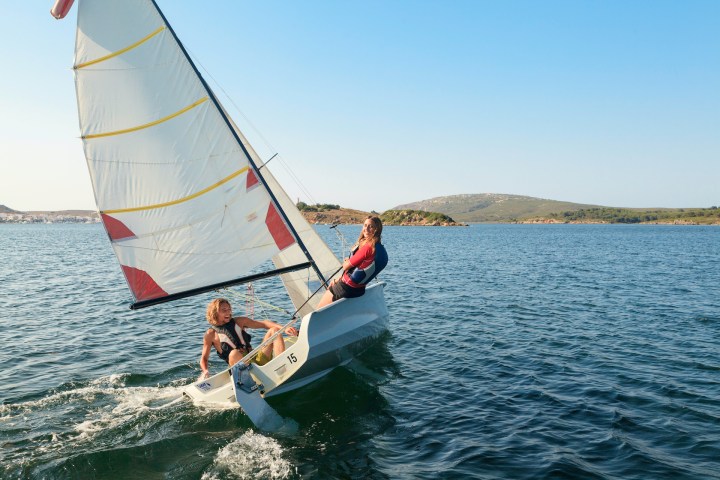a man flying a kite in a boat on a body of water