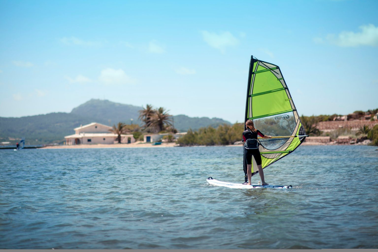 Chica haciendo windsurf en Fornells