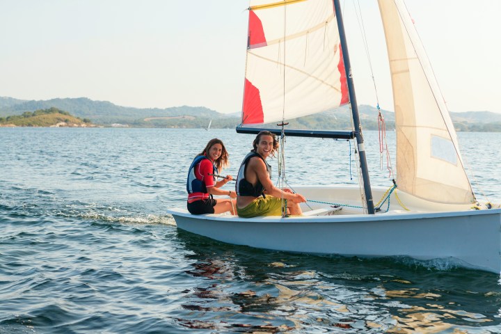 a man riding on the back of a boat in the water