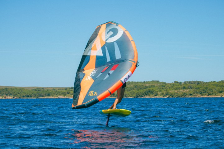 a man flying a kite in a large body of water