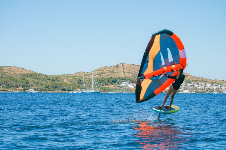 a man flying a kite in a large body of water