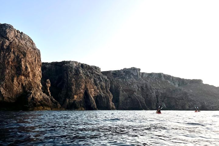 un kayak al lado de los acantilados de la costa norte de Menorca