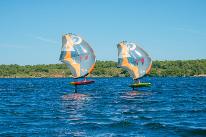 a person flying a kite in a large body of water